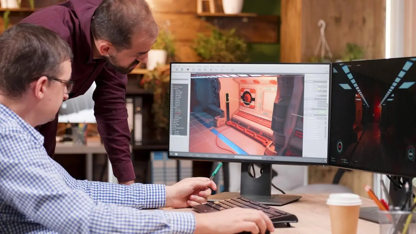 Ein Grafikdesigner in der Gaming-Industrie bespricht mit seinem Kollegen Details, analysiert ein 3D-Leveldesign und erläutert kreative Produktionsideen. Spieleentwickler arbeiten im Firmenbüro an einer Videospielillustration.
